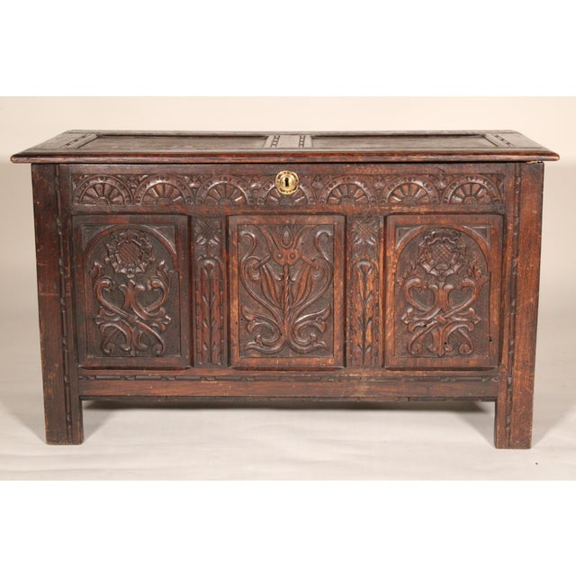 Antique Tudor style carved oak trunk, 19th century. With a two paneled hinged top, the front with 3 carved panels, paneled...