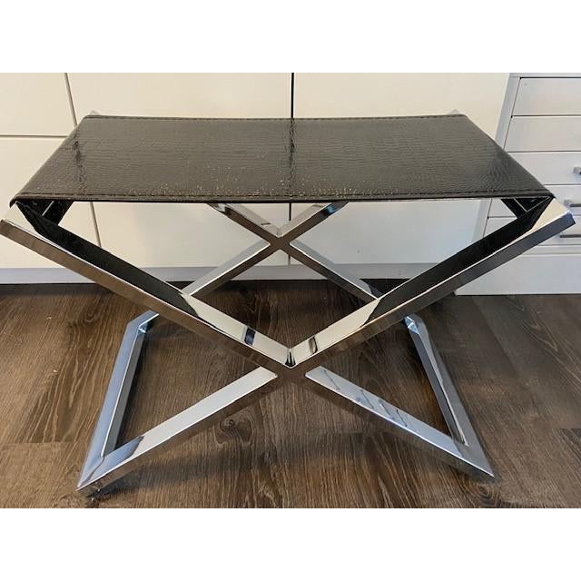 Vintage Mid Century Modern Chrome X-shaped stool. The seat is upholstered with embossed black patent leather to bring a...