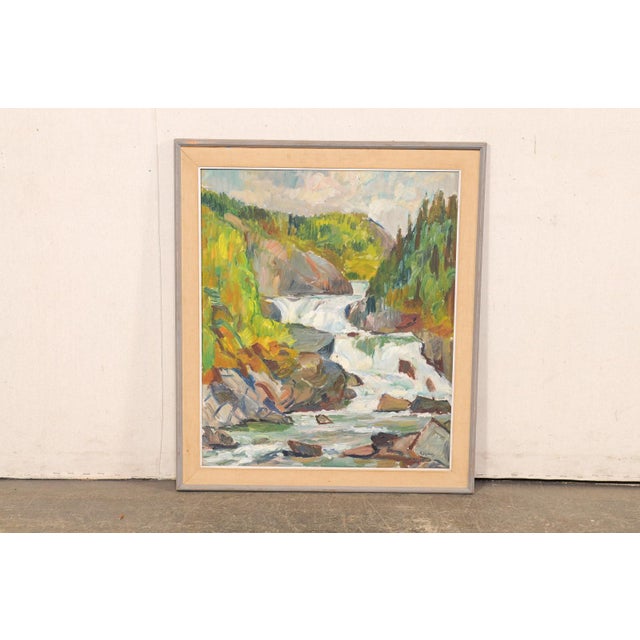 A Swedish framed landscape waterfall painting from the mid 20th century. This mid-century oil painting, with visible,...