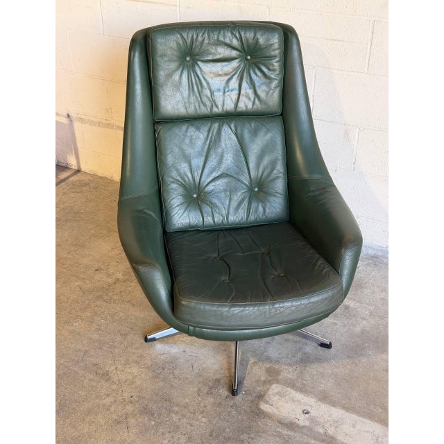 This lounge chair features a high-back contoured shell design with a smooth swivel mechanism. Vintage Danish Mid-Century...