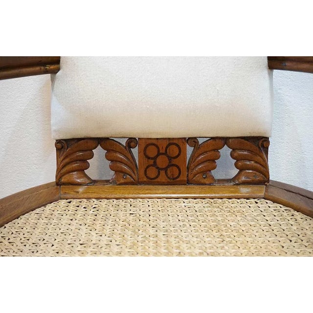 Hand crafted in Eastlake style, this armchair was designed with thick, long curved arms, upholstered back and a caned...