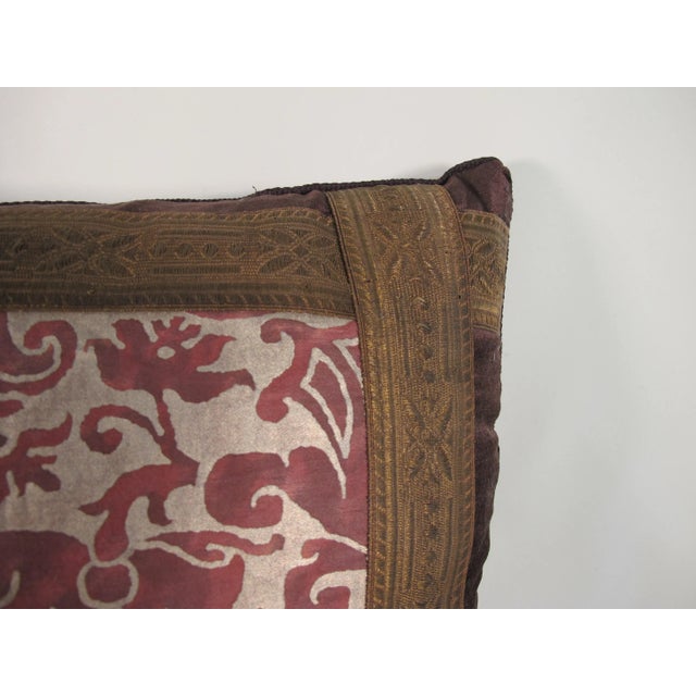 A pillow made from a Fortuny fabric in the iconic Caravaggio pattern, embellished with antique metallic trim and backed...