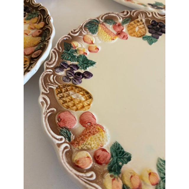 A set of 6 dessert plates by Lefton, each featuring a dimensional majolica-style border of pineapples, grapes, pears, and...