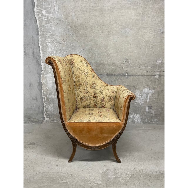 This truly unique vintage fireside armchair features a sweeping high back and a floral damask upholstery fabric with...