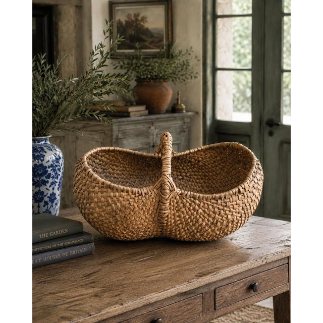 A generously scaled early 20th-century American gathering basket, handwoven from oak splints in the traditional buttocks...