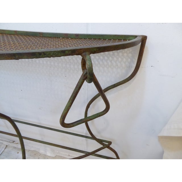 This iron garden console is good for placing potted flowers or plants. It measures 33.5"H x 49"L x 12"D at the top and...