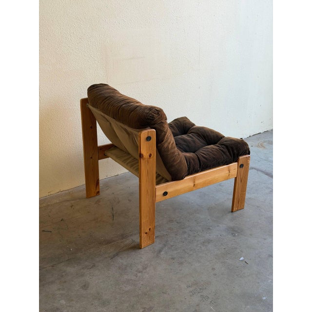 Striking Brutalist lounge chair featuring a bold solid wood frame and generously padded corduroy cushions. The chair has a...