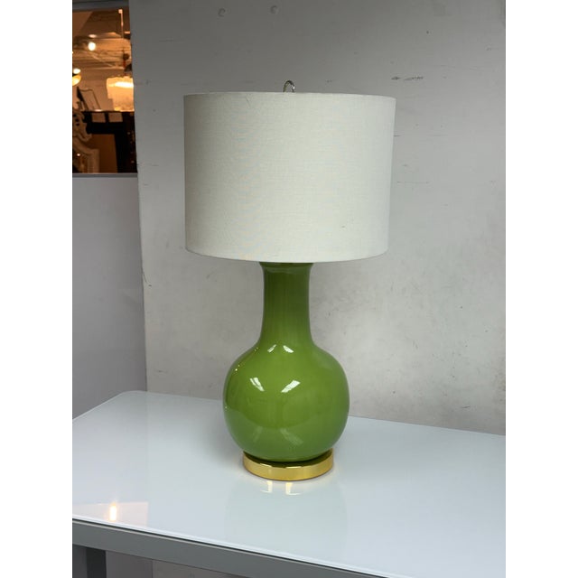Design Plus Gallery presents a Paris Ceramic Table Lamp from Safavieh. The lamp pairs a glossy green ceramic body in a...