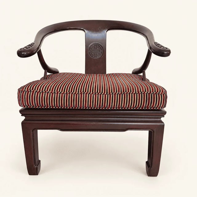 A pair of Chinese horseshoe-back armchairs in the Ming style. They're low and wide, and the crest rail makes one...