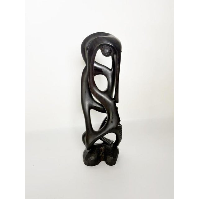 French modernist decorative sculpture dating from the 1980s, carved from dark-stained wood. The composition features an...