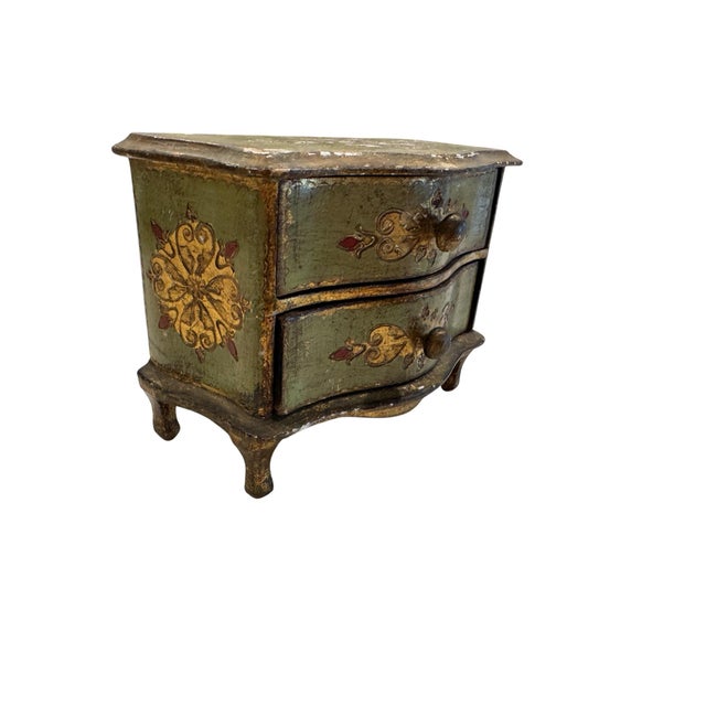 A charming mid century Florentine tabletop chest crafted in Italy and finished in muted olive green with hand-painted gilt...