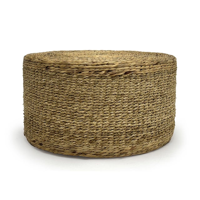 The Woven Ottoman from Zentique is a large handwoven round ottoman in light brown water hyacinth and corn husk leaf. At...