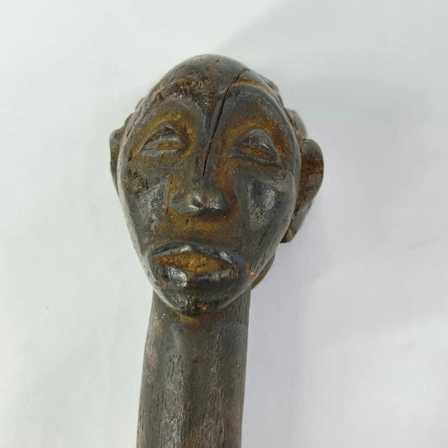 The Luba wood spoon was hand-carved by the Luba people of the Democratic Republic of the Congo. This spoon illustrates a...