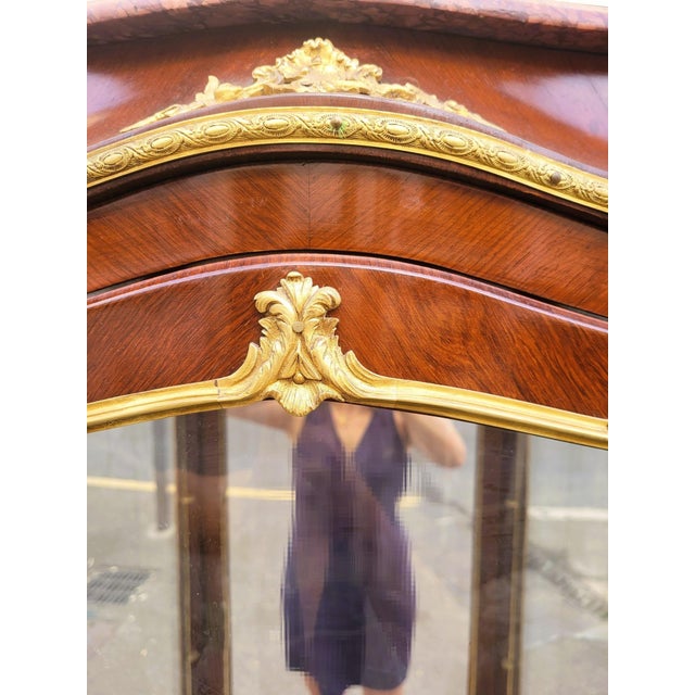 Charming curved display cabinet, featuring marquetry of various wood species and diamond-shaped marquetry "medallions" on...