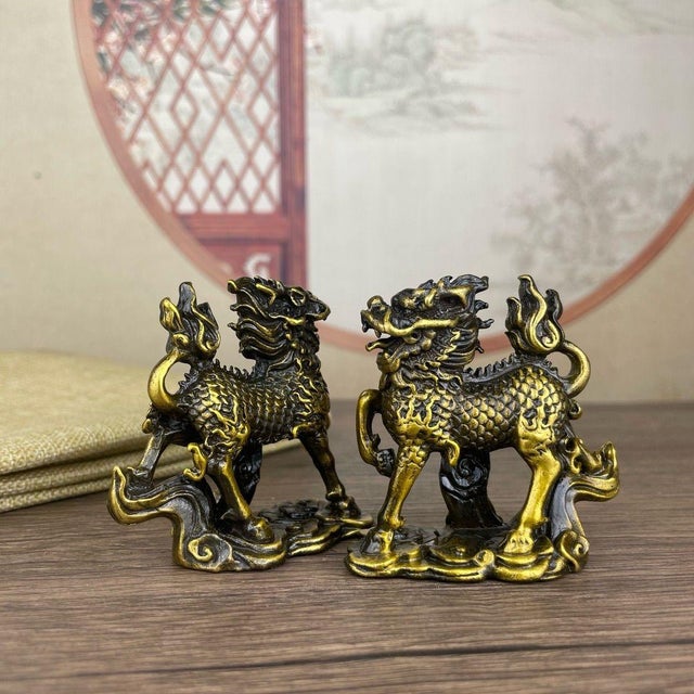 This striking pair of gilt bronze statues depicts Qilin, mythical hooved creatures from traditional folklore, captured in...