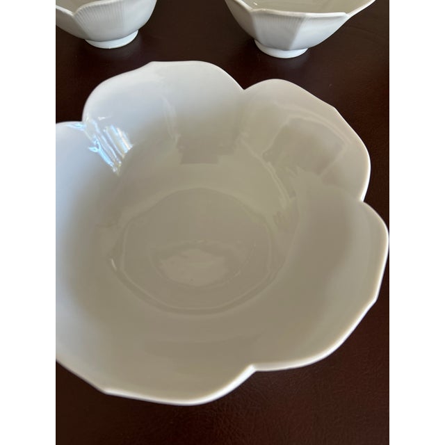 A set of four 1970s white lotus bowls, shaped like a lotus flower in full bloom. Each bowl has softly scalloped petals...