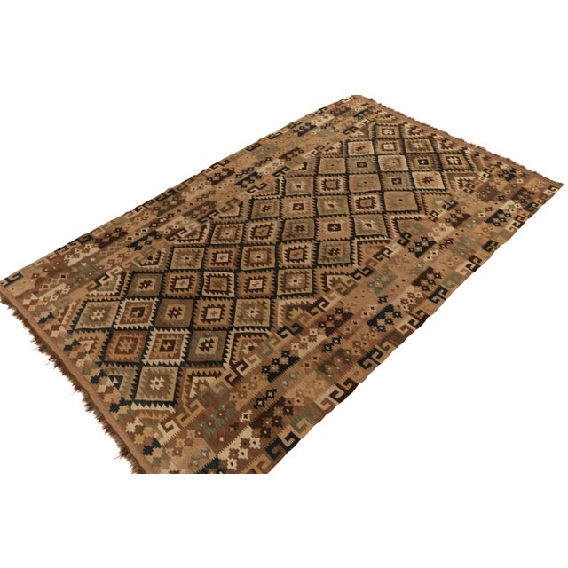 Handwoven in wool, an 8x13 vintage kilim rug from Afghanistan circa 1950-1960. The bold design prefers beige-brown and...