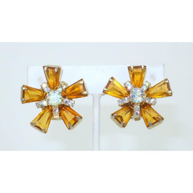 Golden goodness! 1960's gold tone clip-on earrings in a starburst silhouette embellished with amber crystal stones and...