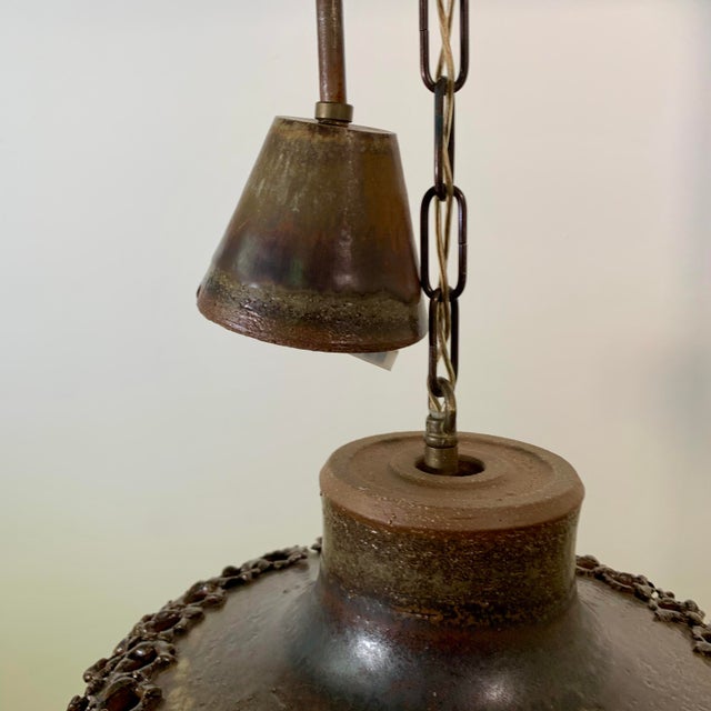 rare, '70s-era perforated stoneware pendant in a brown glossy glaze by ceramist Aksel Larsen for AXELLA STENTØJ. It hangs...
