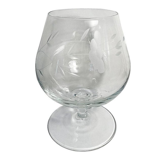A set of four (4) etched crystal brandy sniffer glasses from France. The body of each piece is etched with a bouquet of...