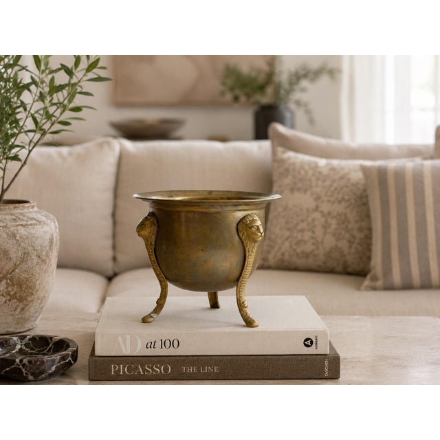Elegant English brass planter raised on three sculptural lion head legs. Rich aged brass and classic tripod form make this...
