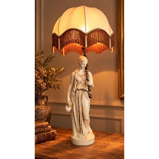A very large 108 cm lamp depicting the Greek goddess Hebe, made of molded resin with an off-white lacquered finish...