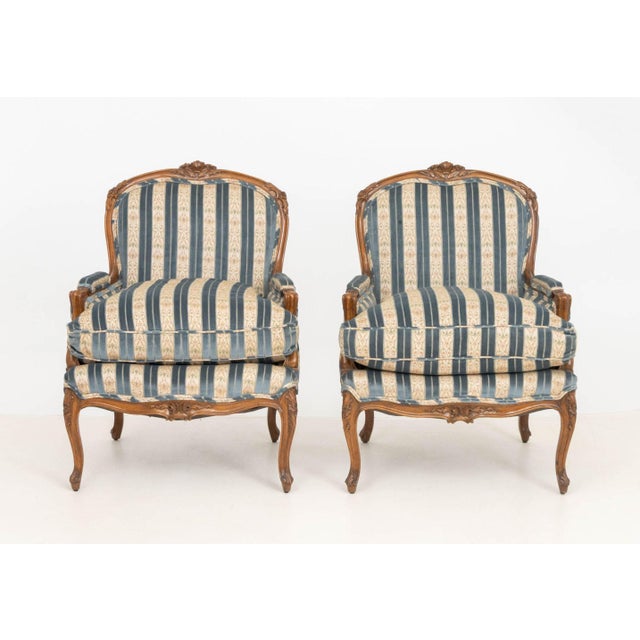Pair of Louis XV Style Blue Velvet Upholstered Walnut Bergeres, each with floral carved cresting and striped upholstery on...