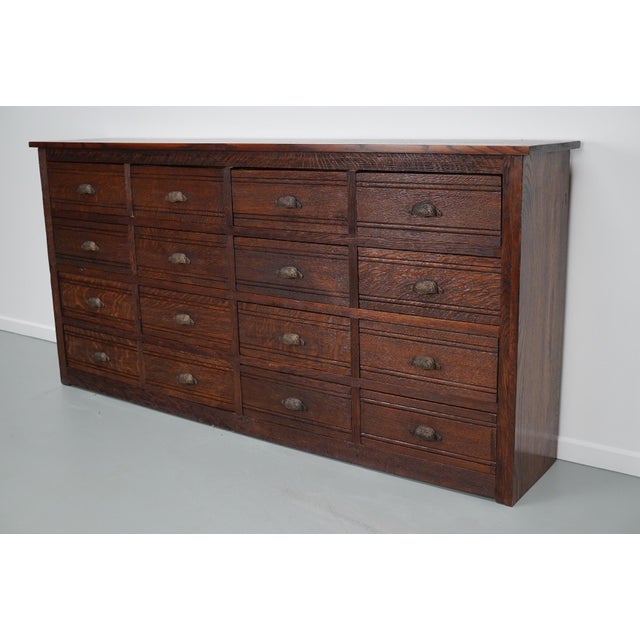 This hardware store cabinet was made around the 1920/1930s in France from oak. It features 16 large drawers with ornate...