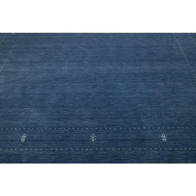 A stunning modern Gabbeh-style hand-woven wool rug boasting a blue color field and exquisite white minimalist design. This...