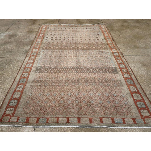 This mid-20th-century Persian Veece accent carpet presents a finely organized geometric composition across a muted blue-...