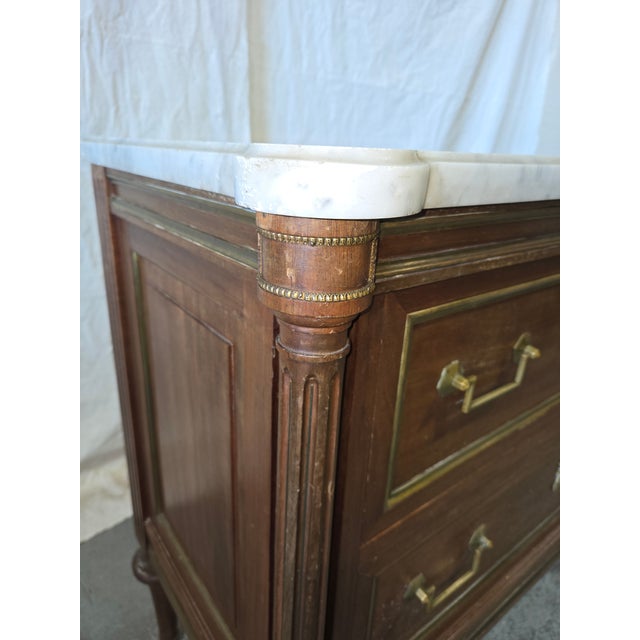 Add neoclassical elegance to your space with this finely crafted Louis XVI-style French commode, featuring a rich mahogany...