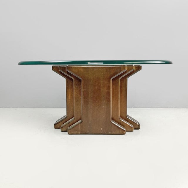 Italian modern wooden coffee table with geometrical base and glass top, 1970s Coffee table with an oval top in transparent...