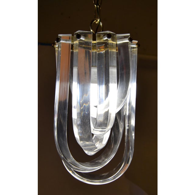 1980s Kovacs attributed Lucite and Brass Ribbon Chandelier, Pendant Light from the Mid-Century Modern Period. In working...