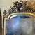 A large French wall or pier mirror with Neoclassical details, the arched top surmounted by a crest of crossed laurel...