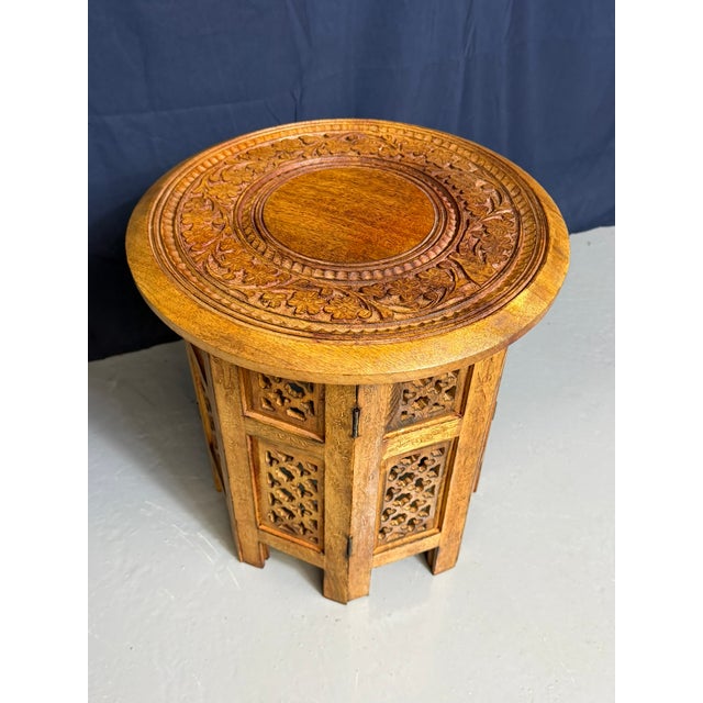 This item is a small hand-carved folding table from Hoshiarpur, India, created around 1950. The table features intricate...