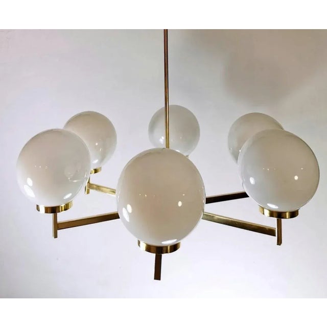 Vintage chandelier with six opaline glass spheres; the structure that supports the spheres is made perfect in brushed and...