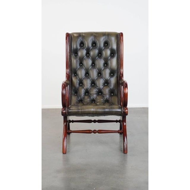 Offered is this elegant green cowhide leather English chesterfield armchair with an ornate wood finish. Add a touch of...