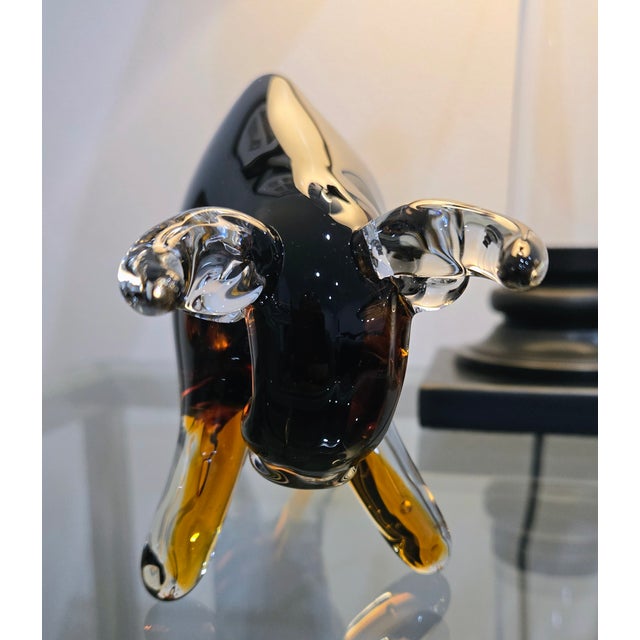 This dynamic blown glass bull sculpture showcases a sleek black body that transitions into warm amber, finished with...