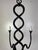 A beautifully hand-forged eight-arm chandelier featuring a dramatic twisted center column and elegantly scrolling arms....