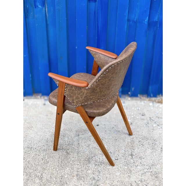 Beautifully crafted Danish modern armchair featuring a sculptural solid teak frame and genuine leather upholstery. The...