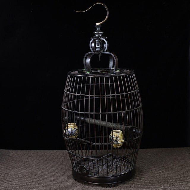 This is a substantial and exquisitely crafted wooden birdcage, featuring an elegant, barrel-shaped body and a domed top....