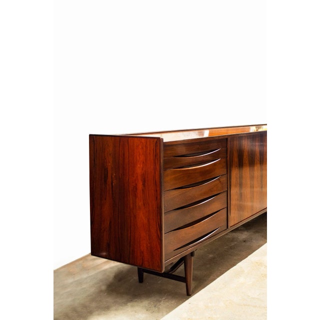 Sliding in rosewood with three sliding doors, adjustable plans, six drawers. Danish production 60's