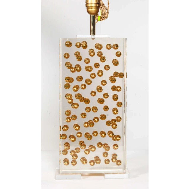 This pair of Lucite lamps features brass ball inclusions. Up to 250V (Europe/UK Standard).The wiring of this item may be...