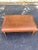 A handsome rectangular ottoman featuring warm cognac leather upholstery, turned wooden legs, and brass-tone nailhead trim....