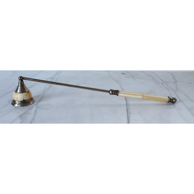 Vintage candle snuffer featuring a conical bell for extinguishing flames and an elongated handle for reaching into deep...