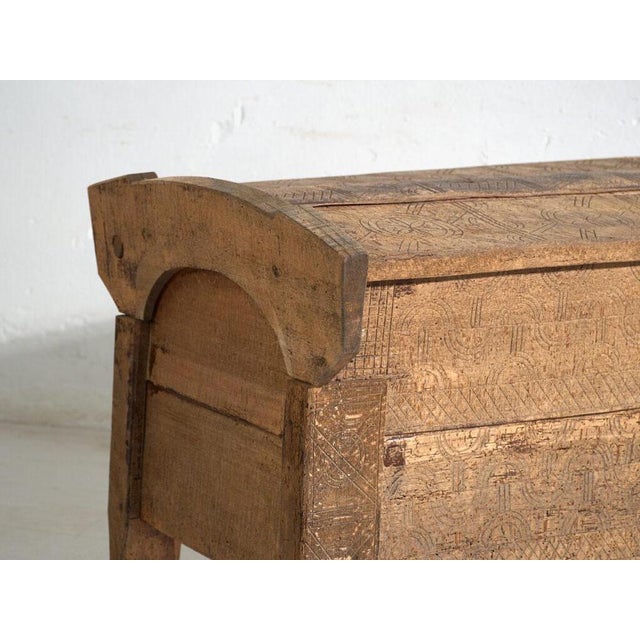 This antique primitive storage bench in wood is a bench with a chest, a lift-up seat and carved sides, of thick board. It...