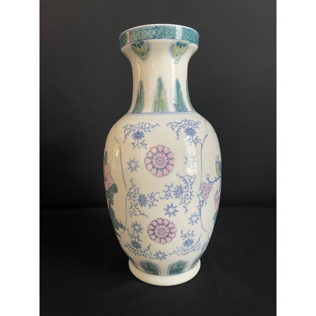 This pretty Porcelain vase features a pair of green parakeets perched on a branch filled with pink cherry blossoms.