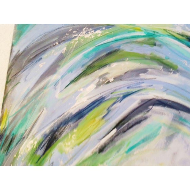 Vibrant large abstract painting in various shades of blues, greens, turquois and white with metallic silver accents. Wired...
