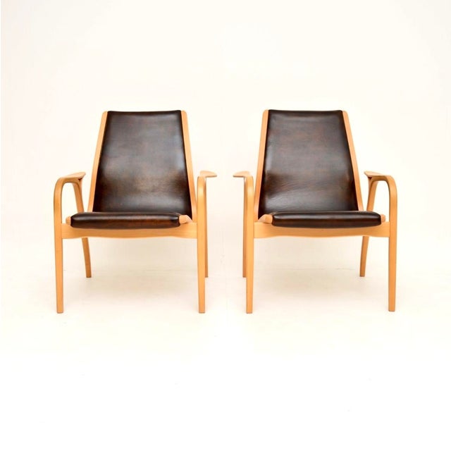 A stunning pair of vintage Swedish leather Lamino armchairs by Yngve Ekstrom. They were made in Sweden by Swedese, they...