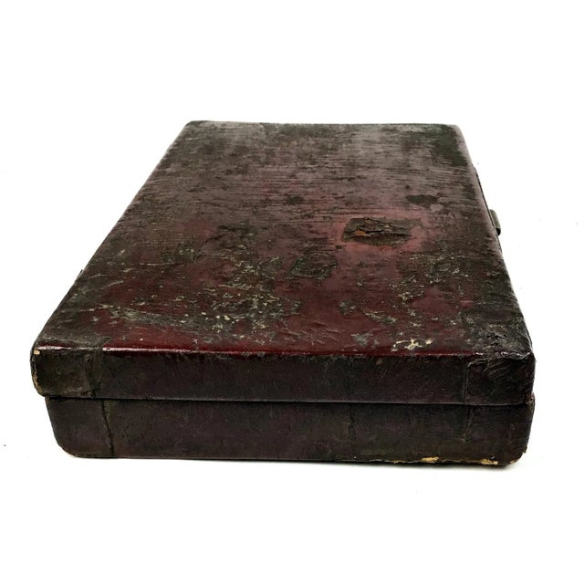 A very old leather covered folding hinged box. The clasp has long ago been broken. The back hinges still hold the box...